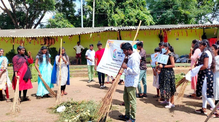 Volunteers sweeping a neighbourhood during a sanitation drive